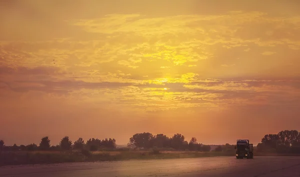 Vrachtwagen reizen bij zonsondergang. — Stockfoto