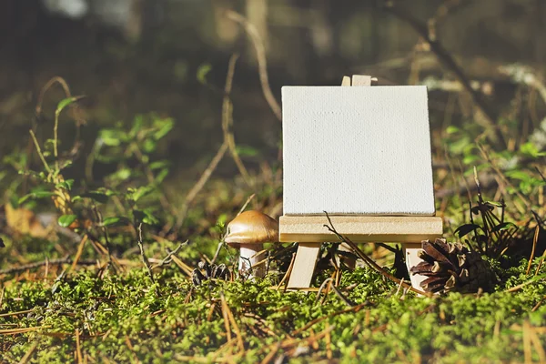 Mini easel on seasonal forest background. — Stock Photo, Image