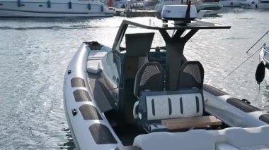 Limasol, Kıbrıs - 22 Mayıs 2025: Limasol Boat Show 2025, Limasol. Şişme bot (RIB) modern siyah beyaz tasarımı, ağ sırtlı iki koltuk, küçük ahşap bir masa ve kabin girişi.