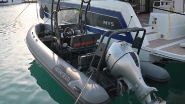 Limasol, Kıbrıs - 22 Mayıs 2025: Limasol Boat Show 2025, Limasol. Arka koltuğu, küçük yemek masası, ahşap güverte, dıştaki motor ve marinada yakındaki tekneler olan lüks bir yat..