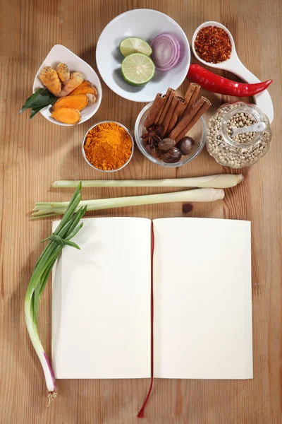 Crear receta con especias y libro de cocina en la mesa — Foto de Stock