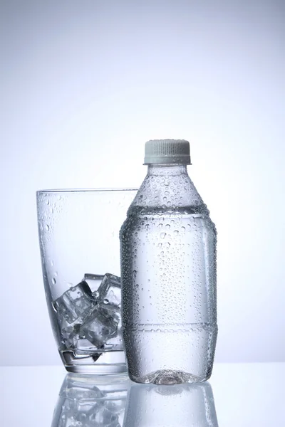 Wasser in Plastikflasche mit Glas — Stockfoto