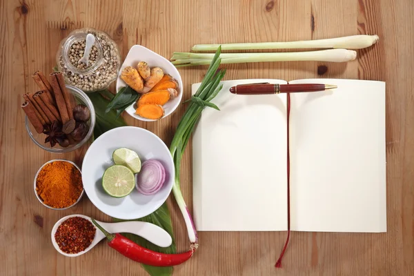 Creating recipe with spices and cookbook on table — Stock Photo, Image