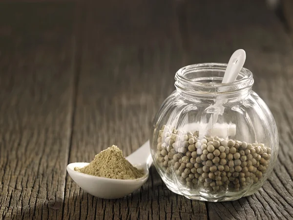 Whole and powdered white peppercorns — Stock Photo, Image