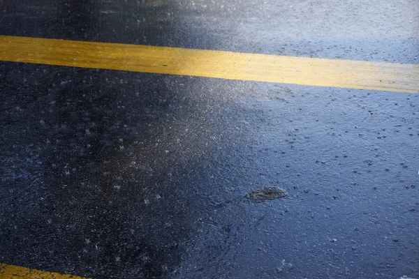 アスファルトの道路で雨が降ってください。 — ストック写真