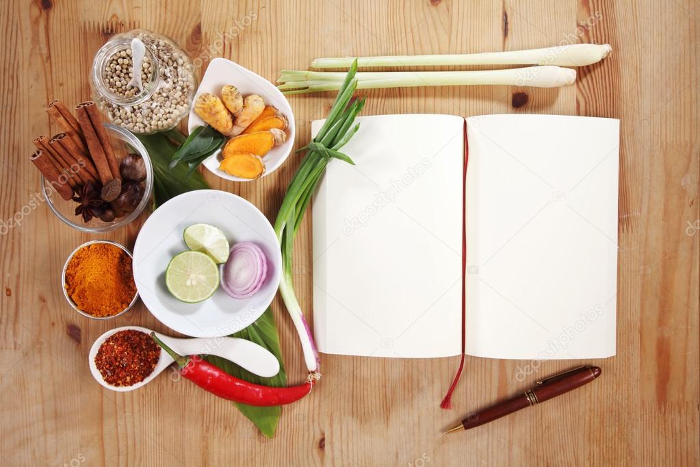 Creating recipe with spices and cookbook on table