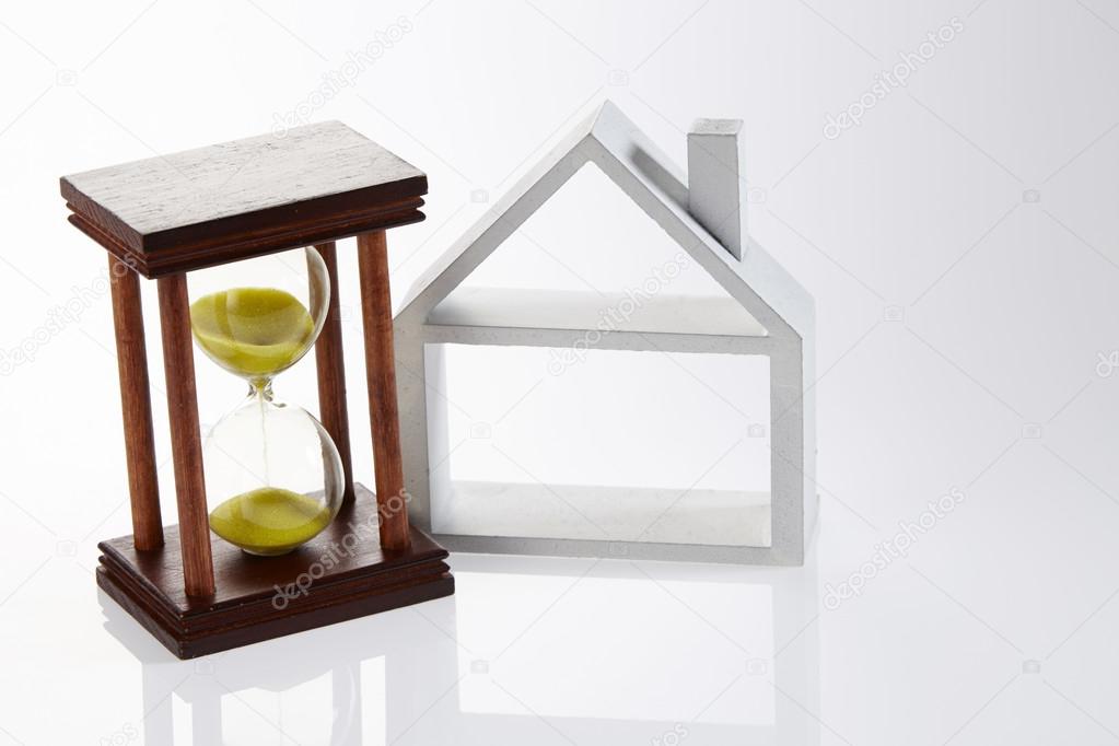 Model house and hour glass on the white background