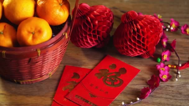 采购产品篮子的柑橘和中国新年装饰 紫罗兰和灯笼的红色背景 — 图库视频影像