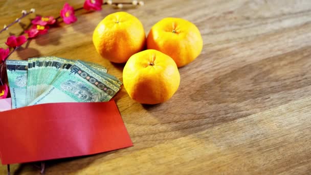 橘子和中国红信封 带有木制背景的现金 — 图库视频影像