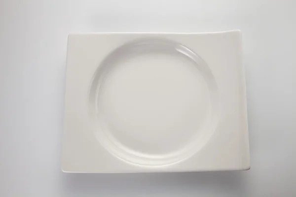 Біла тарілка на білому тлі — стокове фото