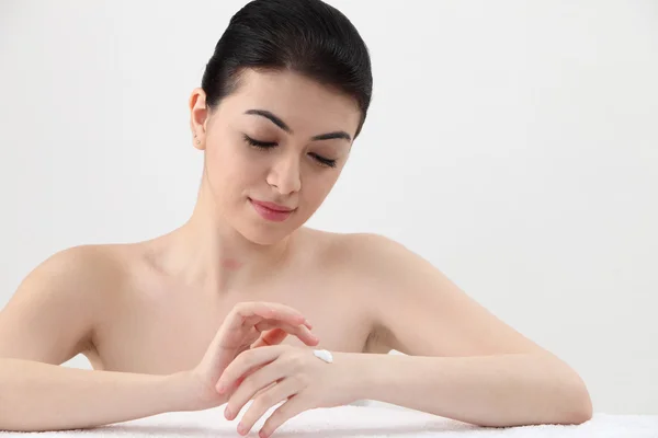 Woman applying lotion — Stock Photo, Image