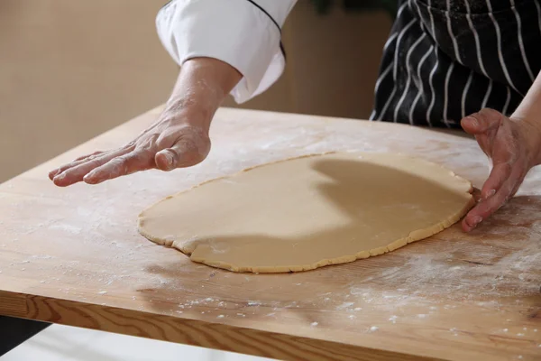 Рука повара и тесто для печенья — стоковое фото