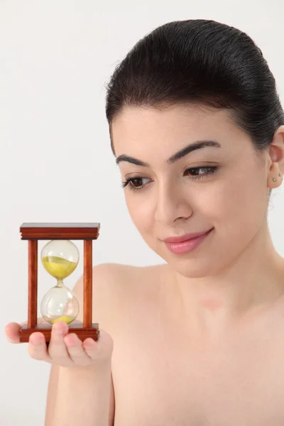 Woman looking at hour glass — Stock Photo, Image