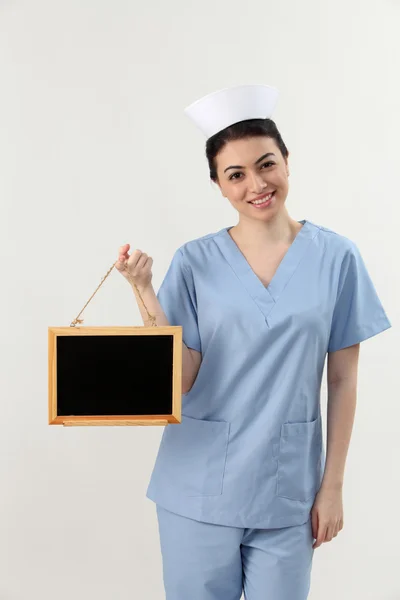 Enfermeira segurando quadro negro — Fotografia de Stock
