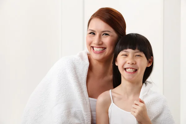 Woman and daughter wrapped in towel 스톡 사진