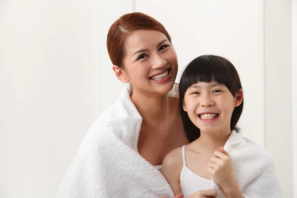 Mulher e filha envoltas em toalha Fotografias De Stock Royalty-Free