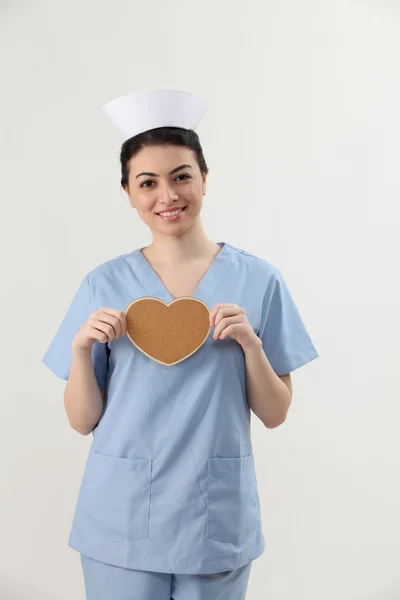 Enfermeira segurando sharpe coração — Fotografia de Stock