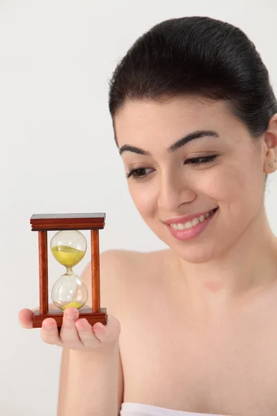 Woman looking at hour glass — Stock Photo, Image