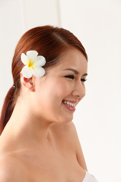 Asian woman with frangipani in ear