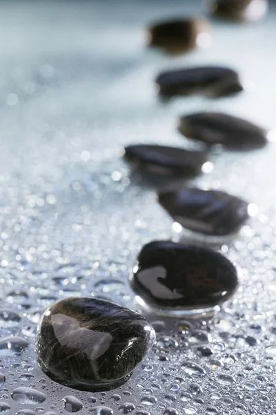 Камни в ряд с капельками воды — стоковое фото