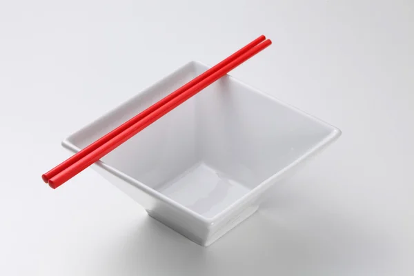 Chopsticks ao lado da tigela quadrada — Fotografia de Stock