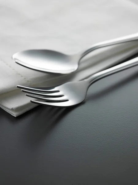 Forchetta e cucchiaio sul tovagliolo sul tavolo — Foto Stock
