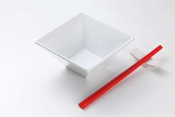 Chopsticks ao lado da tigela quadrada — Fotografia de Stock