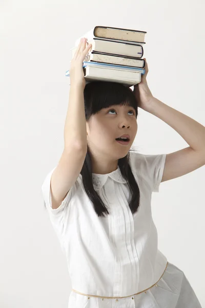 Chica con libros en la cabeza — Foto de Stock
