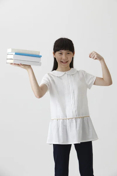 Menina segurando pilha de livro — Fotografia de Stock