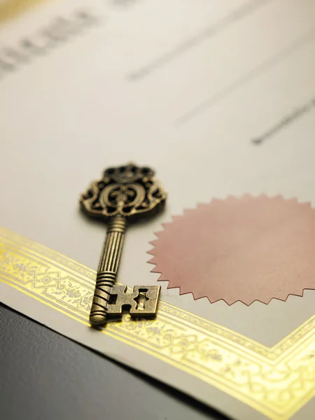 Old key on the certificate — Stock Photo, Image