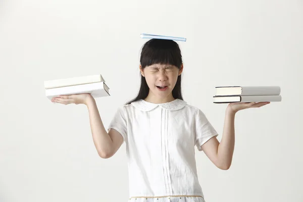 Girl balancing with books — Stock Photo, Image