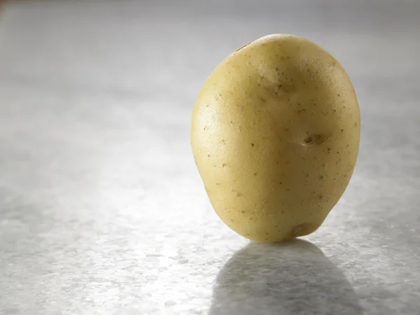 Single potato on table — Stock Photo, Image