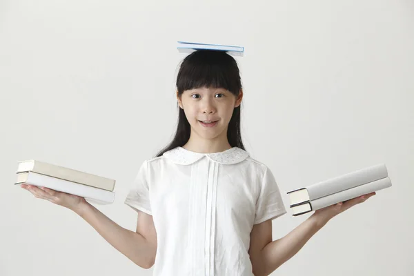 Girl with books on her head — Stock Photo, Image