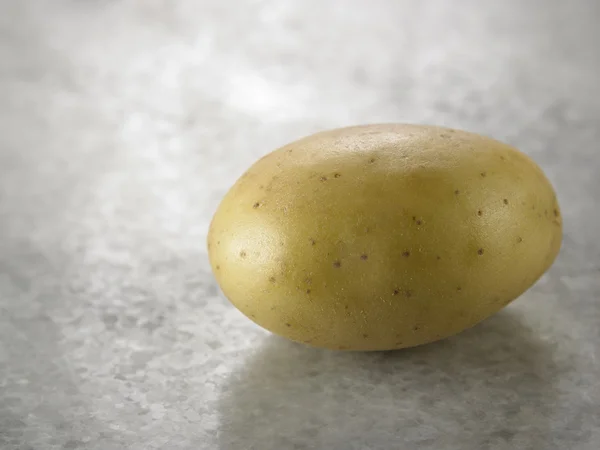 Single potato on table — Stock Photo, Image