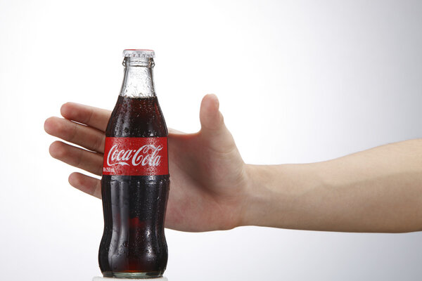 Coca cola bottle and human hand