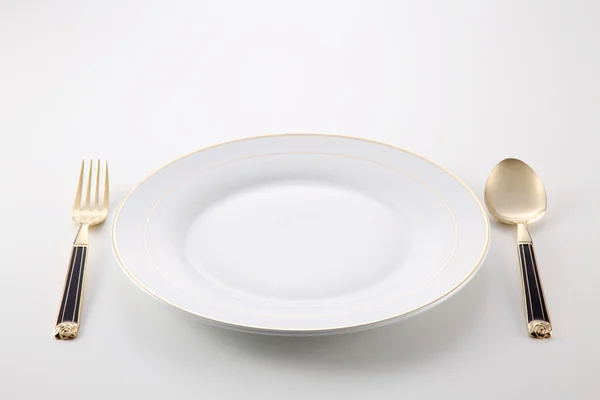 Тарелка с вилкой и ложкой — стоковое фото