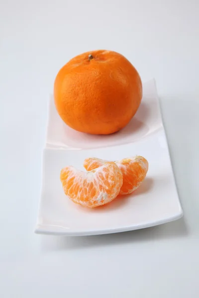 Hele en geschilde mandarijnsinaasappelen — Stockfoto