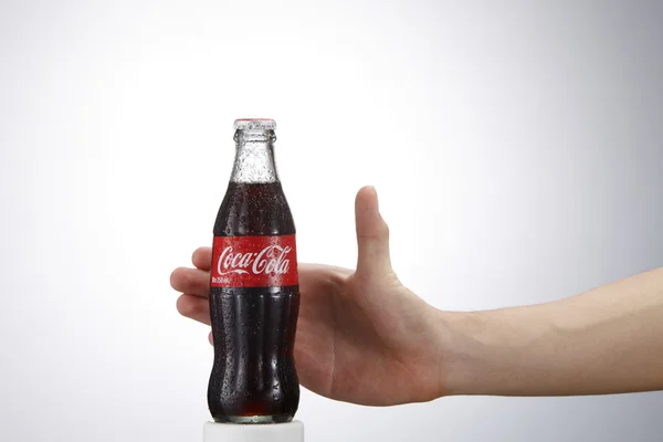Coca cola bottle and human hand — Stock Photo, Image
