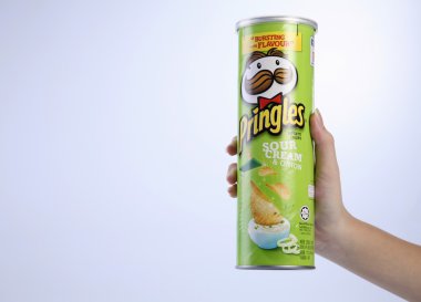 bir tüp patates cipsi tutan el