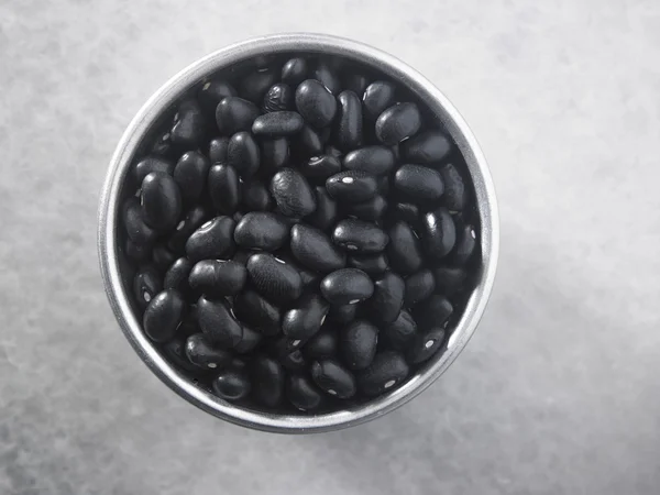 Schwarze Bohnen in einem silbernen Behälter — Stockfoto