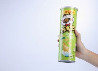 bir tüp patates cipsi tutan el