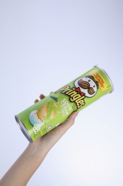 bir tüp patates cipsi tutan el