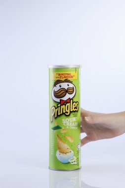 bir tüp patates cipsi tutan el