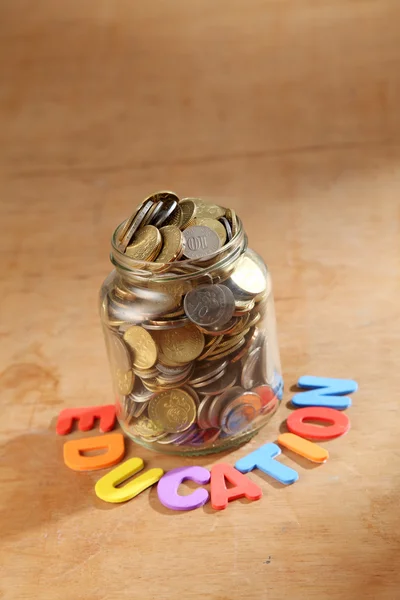 Monedas en tarro con signo de educación —  Fotos de Stock