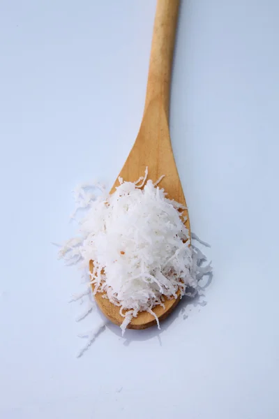 Shredded coconut on the wooden spoon — Stock Photo, Image