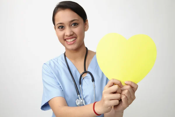 Jolie infirmière tenant coeur jaune — Photo