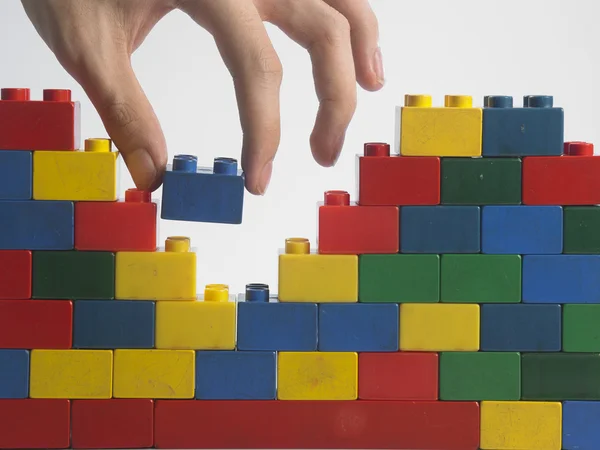 Mano masculina con bloques de construcción coloridos — Foto de Stock