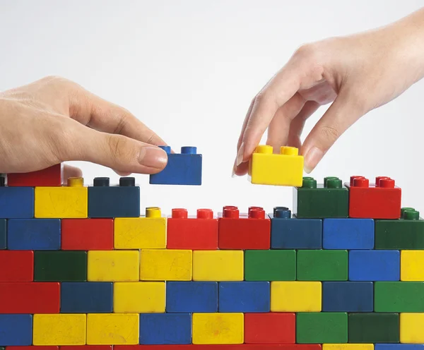Two hands with colorful building blocks — Stock Photo, Image