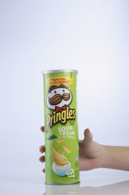 bir tüp patates cipsi tutan el