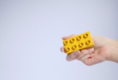 plastik bir blok tutan el